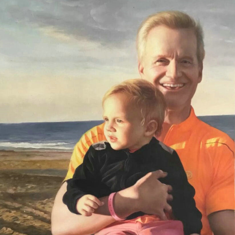 Man holding a child on a beach with a scenic background